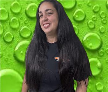 Headshot of employee in black shirt in front of green background