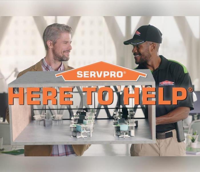 A SERVPRO employee smiling with a customer who is happy with completed work.